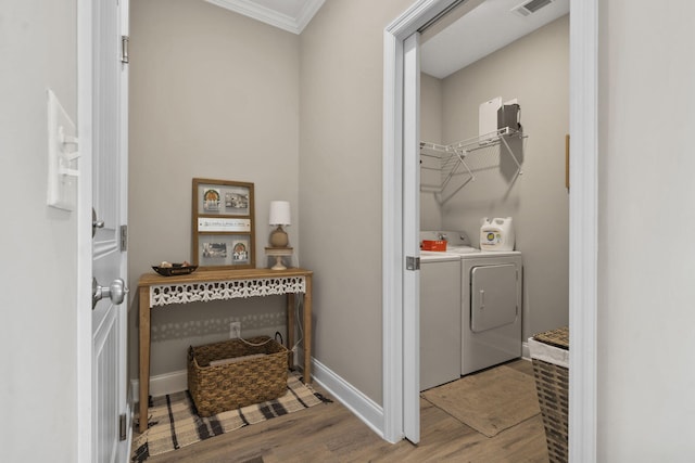 laundry area featuring laundry area, independent washer and dryer, visible vents, wood finished floors, and ornamental molding