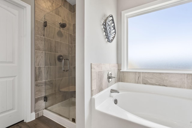 bathroom featuring a stall shower and a garden tub