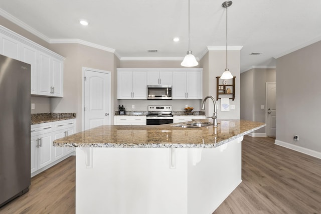 kitchen with appliances with stainless steel finishes, a sink, baseboards, ornamental molding, and light wood-style flooring