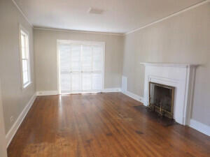 unfurnished living room with dark hardwood / wood-style floors and crown molding