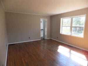 empty room with dark hardwood / wood-style flooring