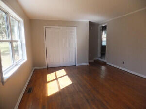 unfurnished bedroom with a closet and dark wood-type flooring