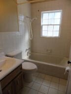 full bathroom featuring washtub / shower combination, tile patterned flooring, vanity, and toilet