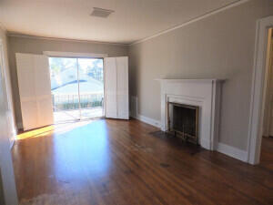 unfurnished living room featuring crown molding and dark hardwood / wood-style flooring