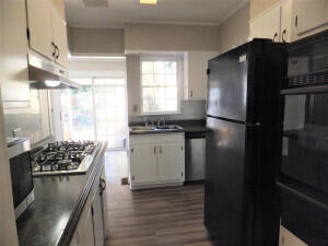 kitchen with sink, white cabinets, dark wood-type flooring, and appliances with stainless steel finishes