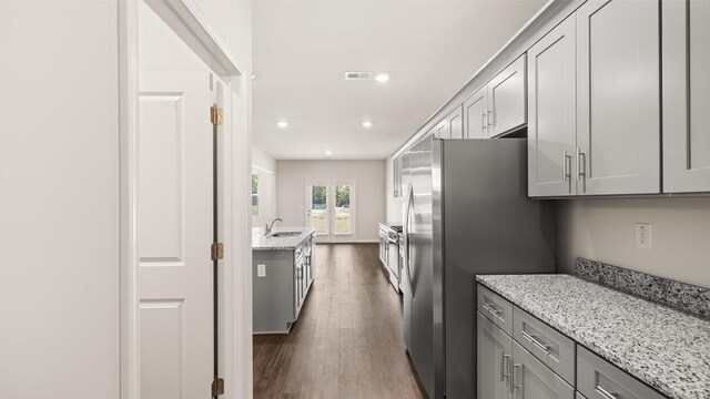 unfurnished dining area featuring dark hardwood / wood-style flooring, sink, and a chandelier