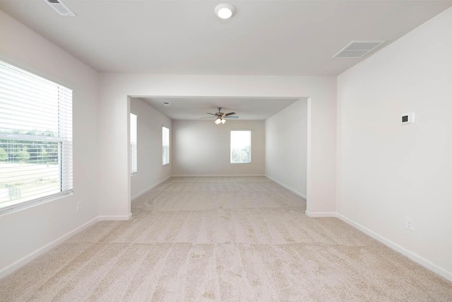 spare room featuring ceiling fan and light colored carpet