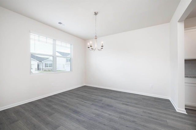 unfurnished dining area with dark hardwood / wood-style floors and a notable chandelier