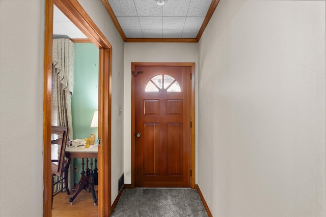 doorway featuring ornamental molding and carpet floors