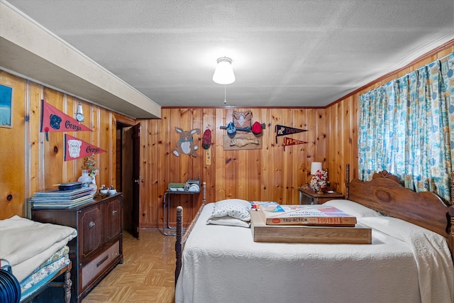 bedroom with a textured ceiling, ornamental molding, and light parquet floors