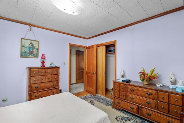 bedroom featuring crown molding and a closet