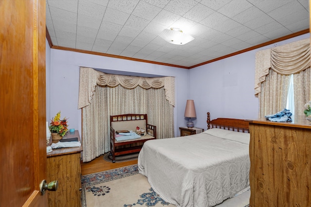 bedroom with hardwood / wood-style floors and ornamental molding