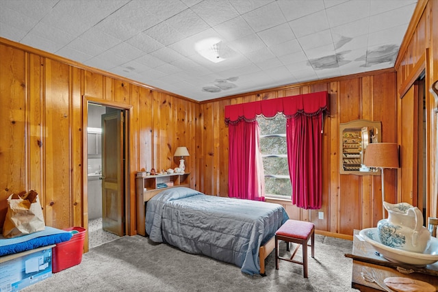 bedroom with crown molding, carpet floors, and wooden walls