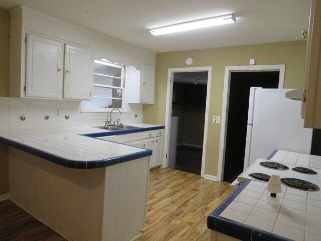 2202 Vireo Dr, North Augusta, SC 29841 - kitchen with tile counters, a peninsula, and white cabinetry
