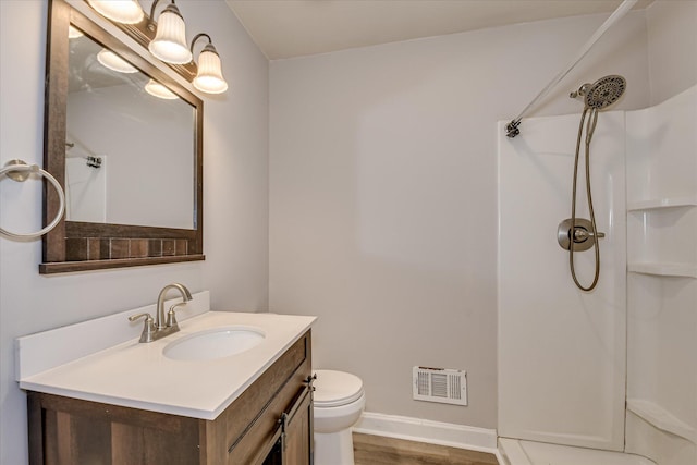 full bathroom featuring a shower, toilet, vanity, and baseboards