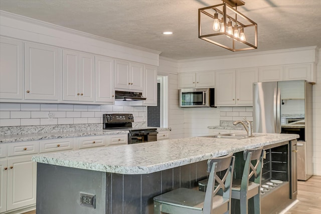 kitchen with appliances with stainless steel finishes, a sink, tasteful backsplash, under cabinet range hood, and crown molding