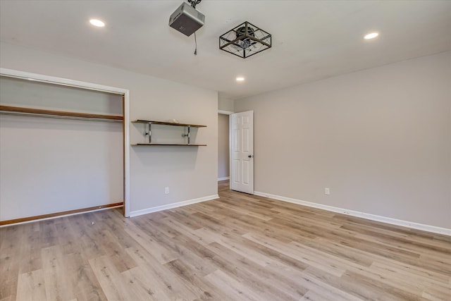 unfurnished bedroom with light wood-style floors, baseboards, recessed lighting, and a closet