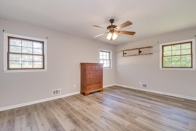 spare room featuring light wood-style flooring, ceiling fan, and baseboards