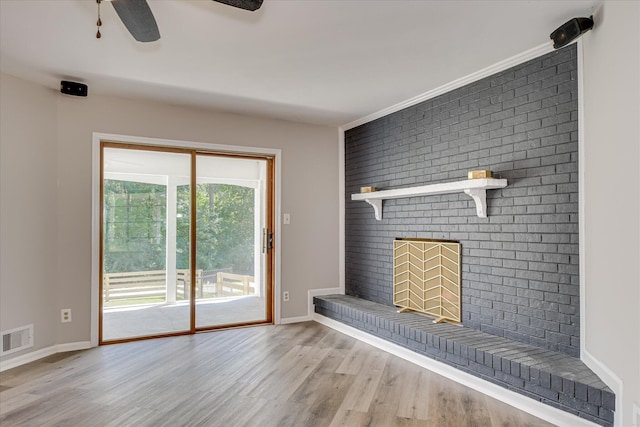 unfurnished living room featuring a brick fireplace, light wood finished floors, and baseboards