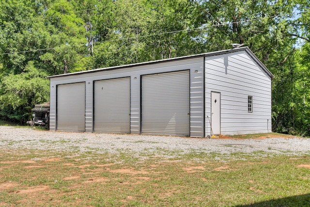detached garage featuring view of wooded area