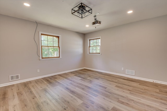 unfurnished room with wood finished floors, recessed lighting, and baseboards