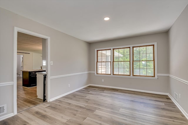 spare room with light wood-style flooring, baseboards, and recessed lighting
