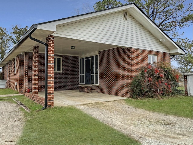 rear view of house featuring a carport and a yard