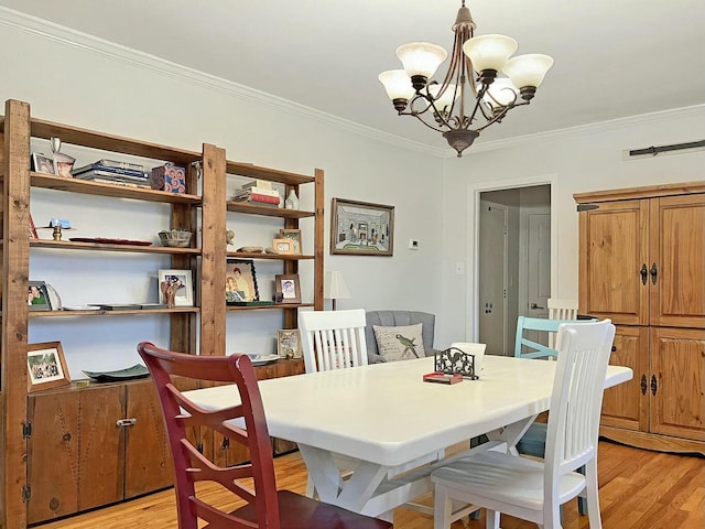 dining space featuring crown molding, light hardwood / wood-style flooring, and a chandelier