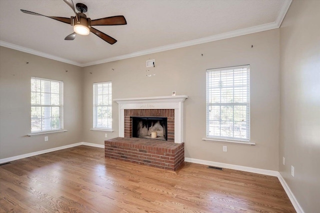 unfurnished living room featuring hardwood / wood-style flooring, ceiling fan, ornamental molding, and a fireplace