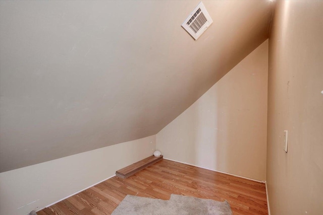 additional living space featuring light hardwood / wood-style floors and vaulted ceiling