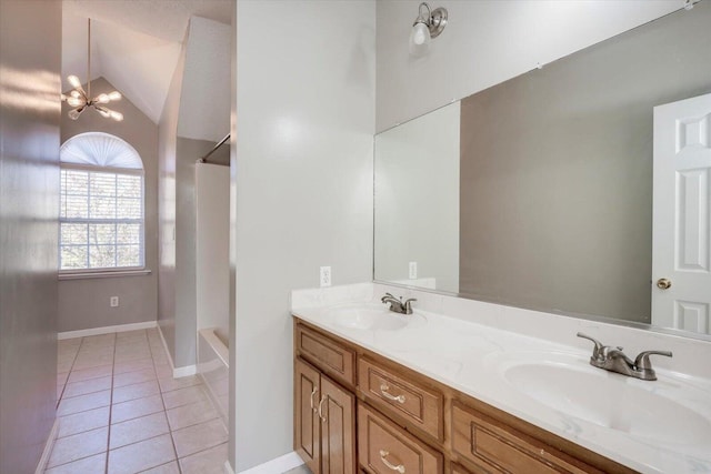 bathroom with vanity, an inviting chandelier, tile patterned floors, and vaulted ceiling