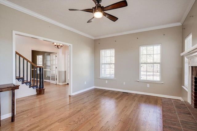 unfurnished living room featuring a brick fireplace, ceiling fan with notable chandelier, a textured ceiling, crown molding, and hardwood / wood-style floors