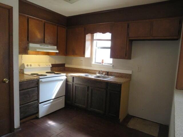 kitchen featuring dark wood-type flooring, a sink, under cabinet range hood, and white electric range oven