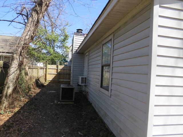 view of home's exterior featuring fence, a chimney, and central air condition unit