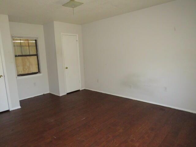 empty room featuring wood finished floors and baseboards