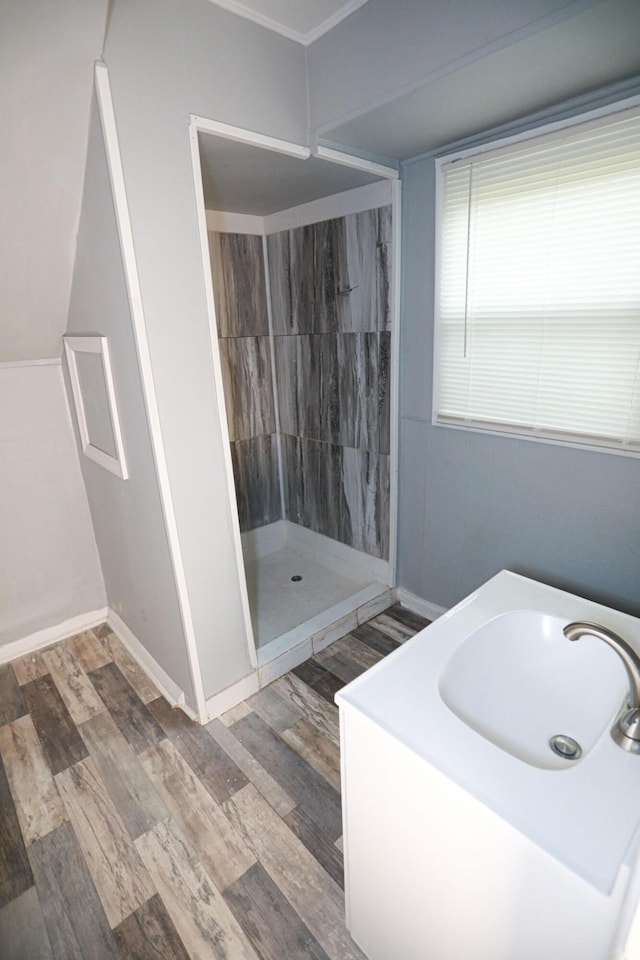 bathroom with a shower, hardwood / wood-style floors, and sink