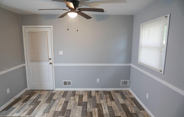 empty room with dark hardwood / wood-style flooring and ceiling fan