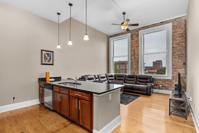 kitchen with pendant lighting, dishwasher, sink, and brick wall