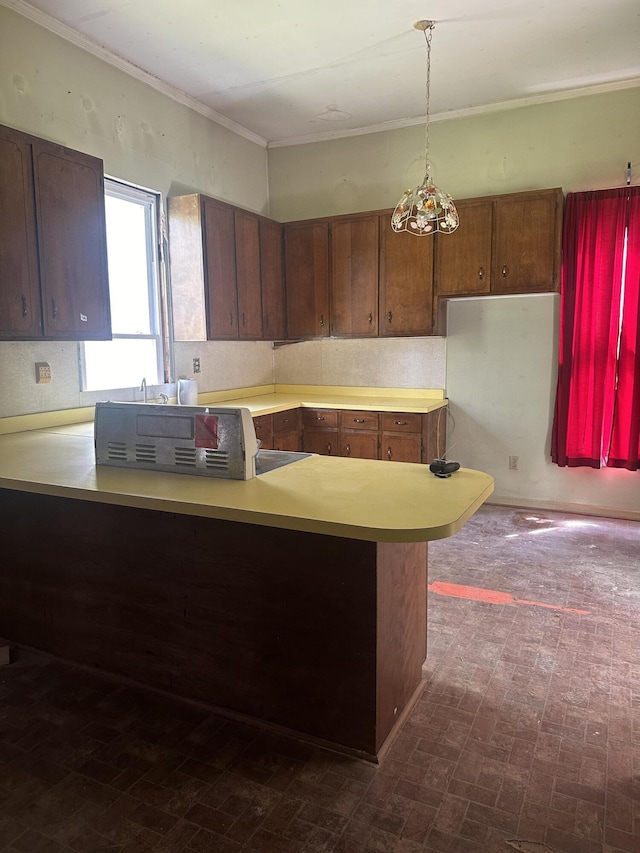 kitchen with kitchen peninsula, pendant lighting, and ornamental molding