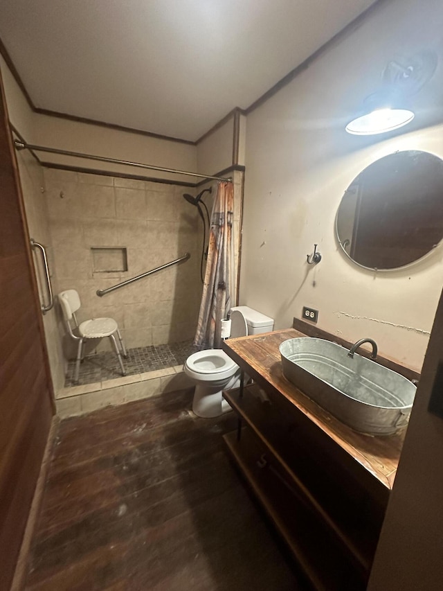 bathroom with hardwood / wood-style flooring, vanity, toilet, and walk in shower