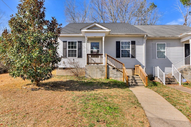 view of front of home featuring a shingled roof and a front lawn