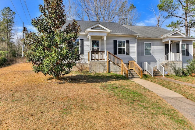 view of front of property featuring a shingled roof and a front lawn