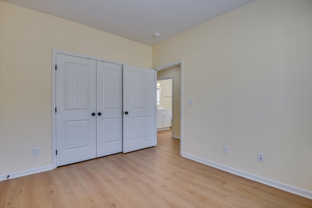 unfurnished bedroom with a closet and light hardwood / wood-style flooring