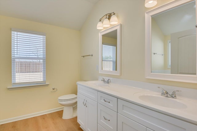 bathroom featuring vanity, hardwood / wood-style flooring, vaulted ceiling, and toilet