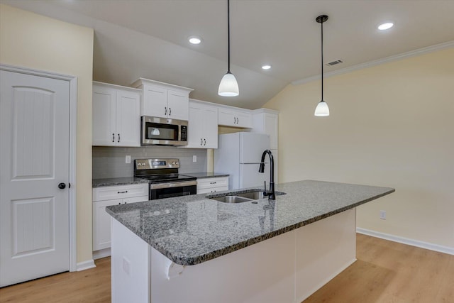 kitchen featuring decorative light fixtures, white cabinetry, sink, dark stone counters, and stainless steel appliances