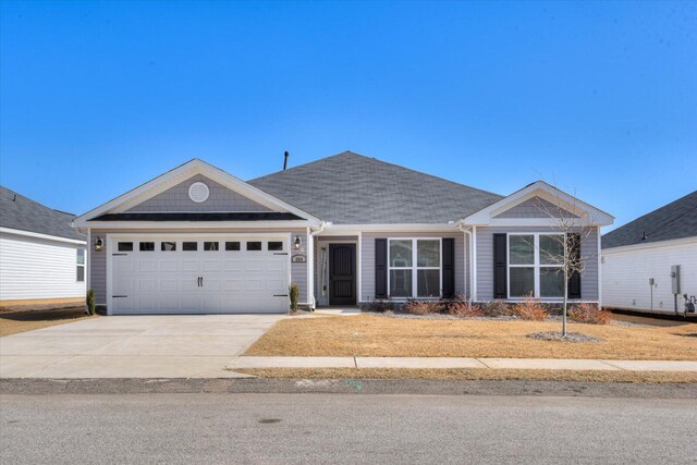 ranch-style home with a garage and a front lawn