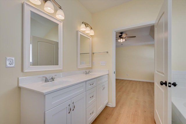 bathroom featuring hardwood / wood-style flooring, vanity, a bathtub, and ceiling fan