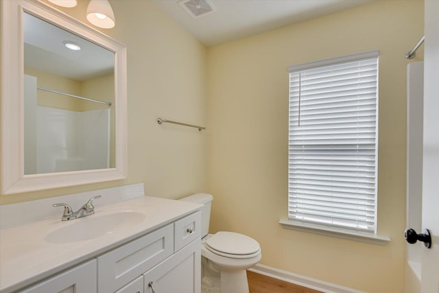 bathroom with vanity, toilet, and walk in shower