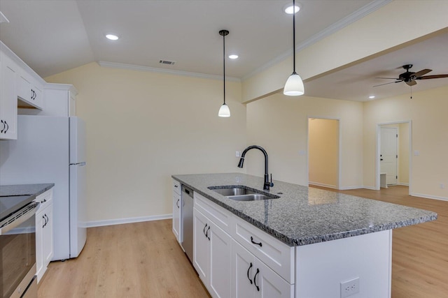 kitchen with appliances with stainless steel finishes, a kitchen island with sink, sink, and white cabinets