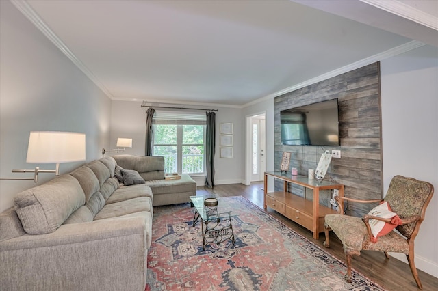 living room with wood finished floors, ornamental molding, and baseboards